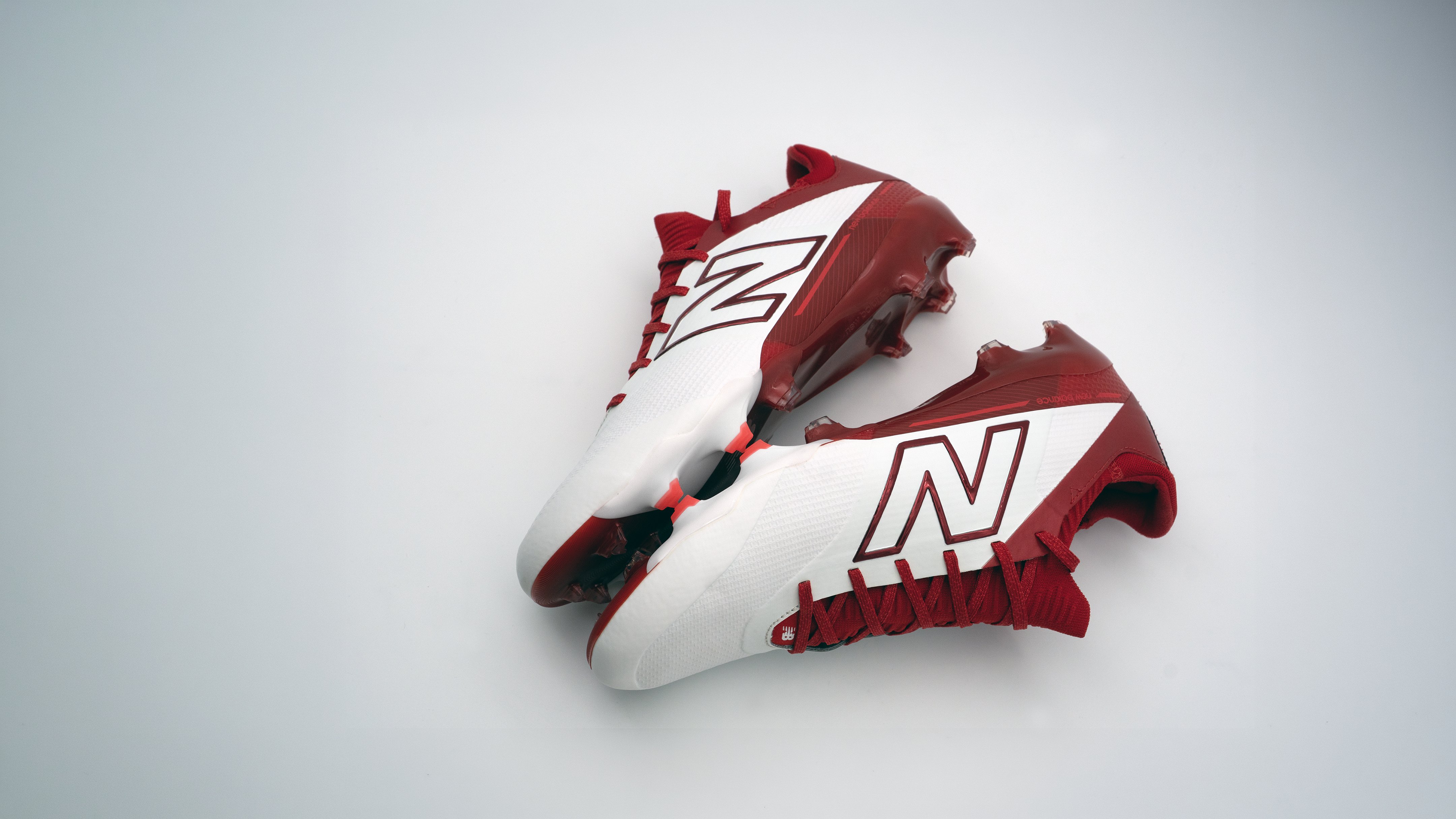 New Balance Prodigy football cleats, pair, white and red colorway